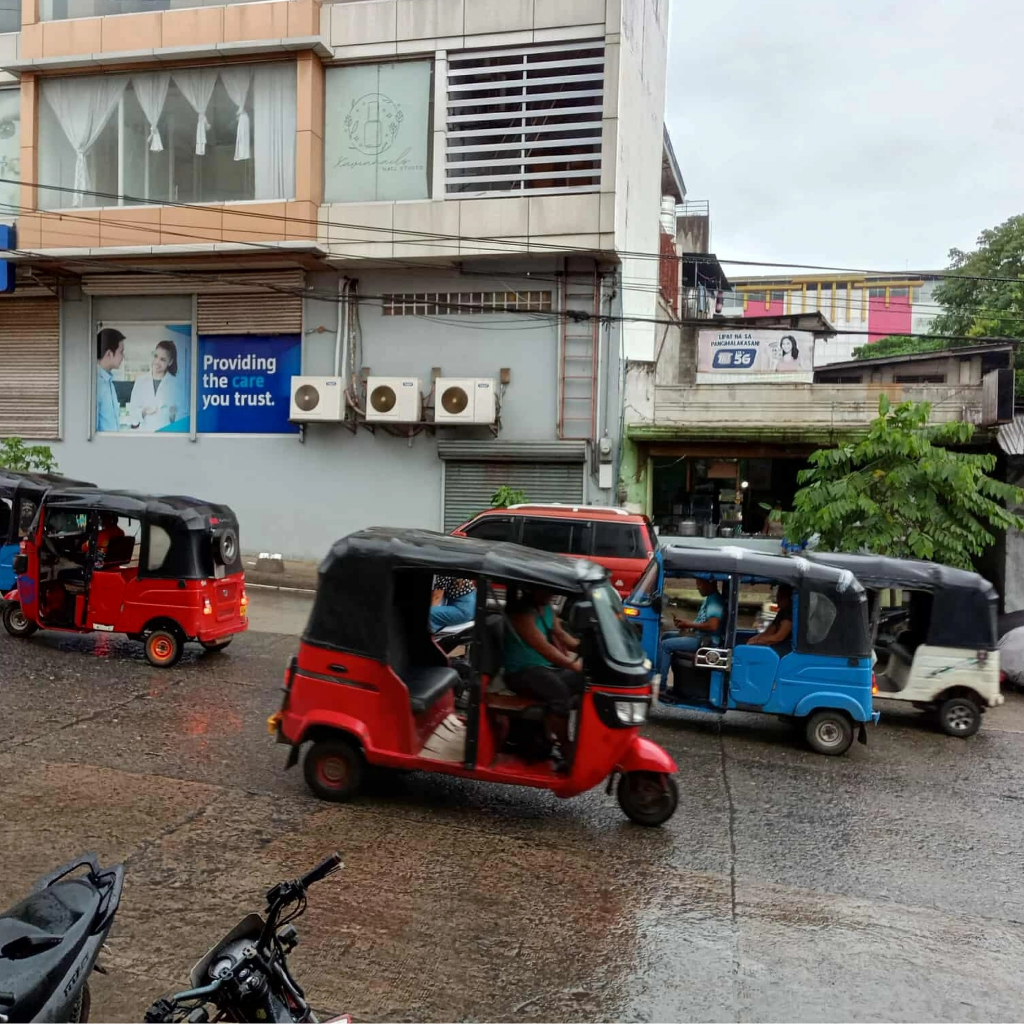 Pagadian's unique tricycles with sidecars parked along a street lined with palm trees